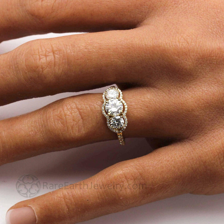Rose Gold Moissanite Engagement Ring on Finger, Vintage Inspired Three Stone Ring with Diamond Accents | Vintage Inspired Engagement Ring from  Rare Earth Jewelry